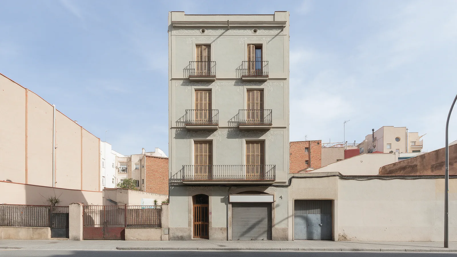 Carrer de Verdi 31 — twenty-four flats over the shuttered pharmacy.